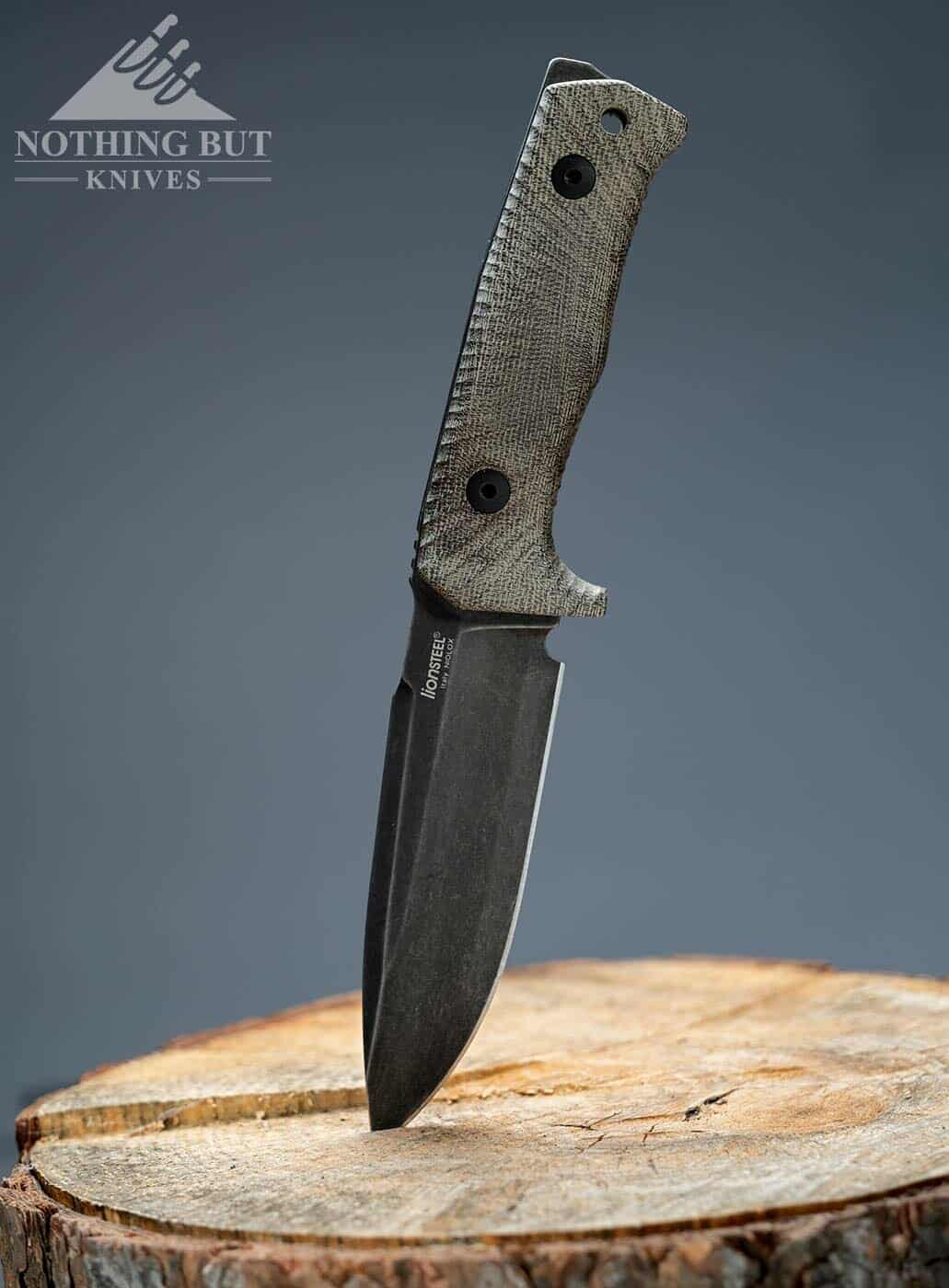 The LionSteel T5 tactical knife sticking out of a stump.