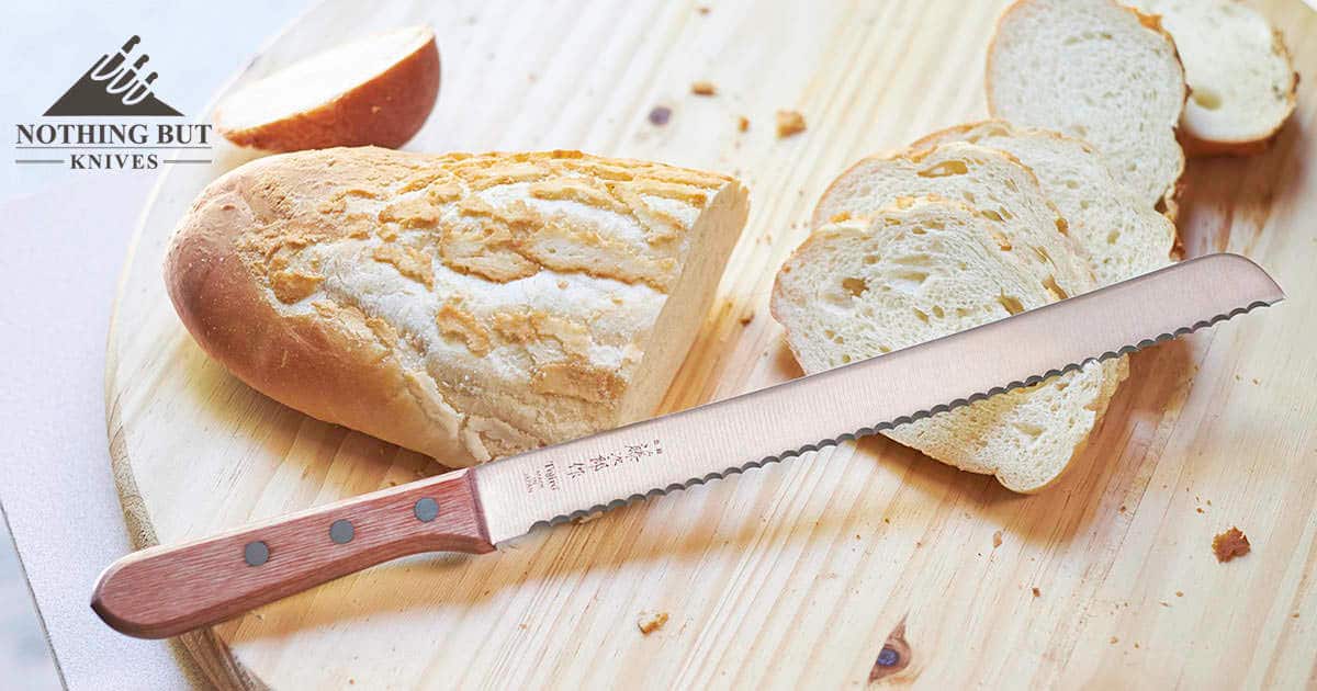 Tojiro F-737 Bread Knife sitting on a loaf of recently cut Dutch Crust Bread.