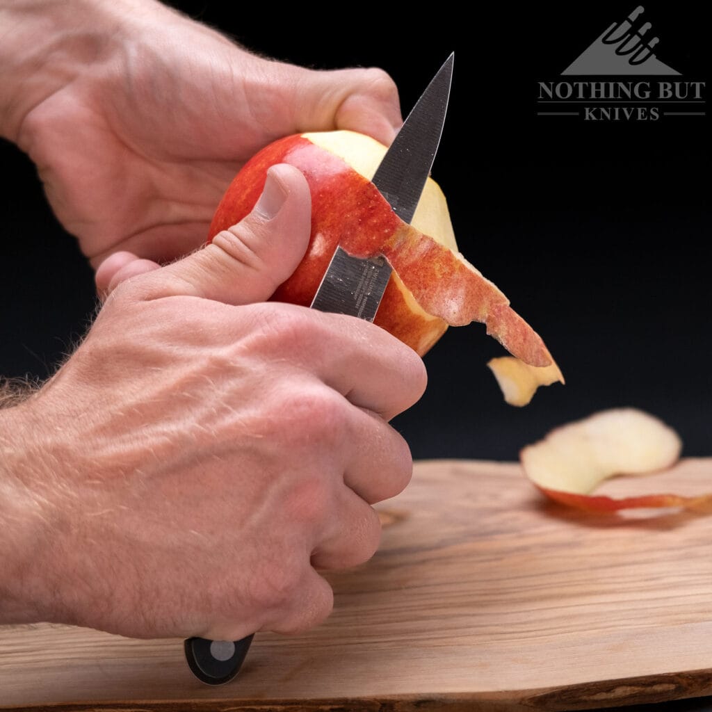 Best High-End Knife Sets For Professional Or Home Use - Image 39 Peeling a red apple with the Zwilling Professional S paring knife.