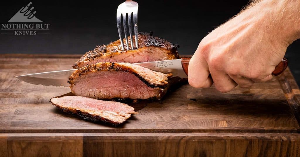 Best Kitchen Knife Sets Under $200 - 2023 Update 7 Close-up of the Buck 932 slicer knife with rosewood handle scales slicing through tri-tip.