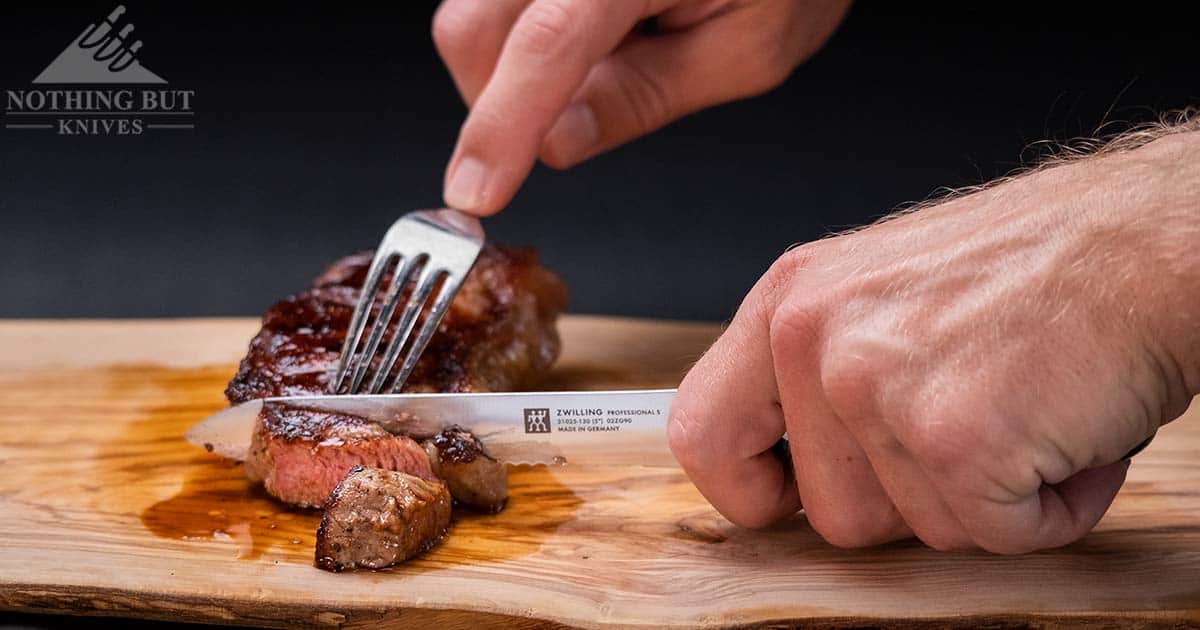 The versatile Professional S utility knife is great in the kitchen or on a road trip. It is shown here cutting meat.