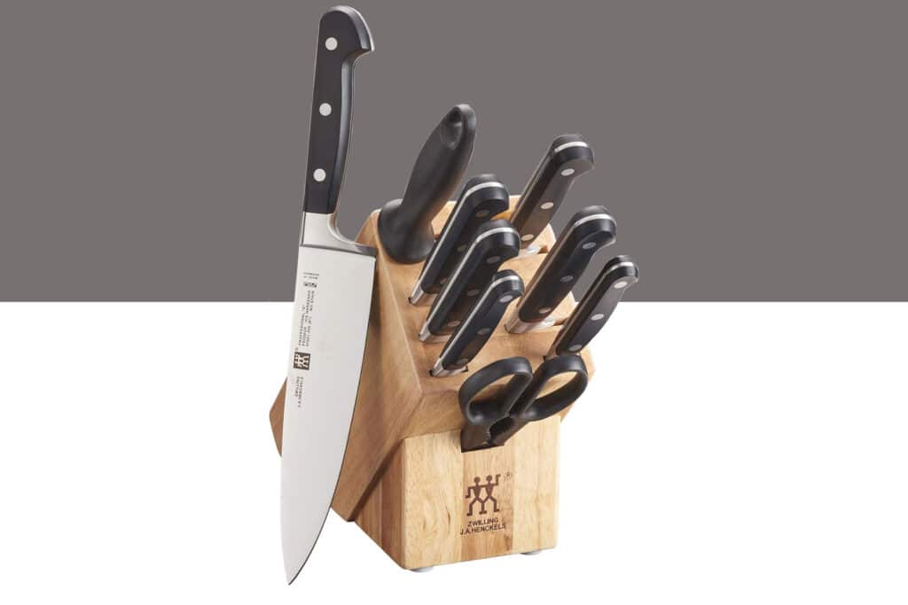 Best High-End Knife Sets For Professional Or Home Use - Image 36 The Zwiling Professional S 10-piece knife set shown here with all the knives inside their storage block in front of a split grey and white background.