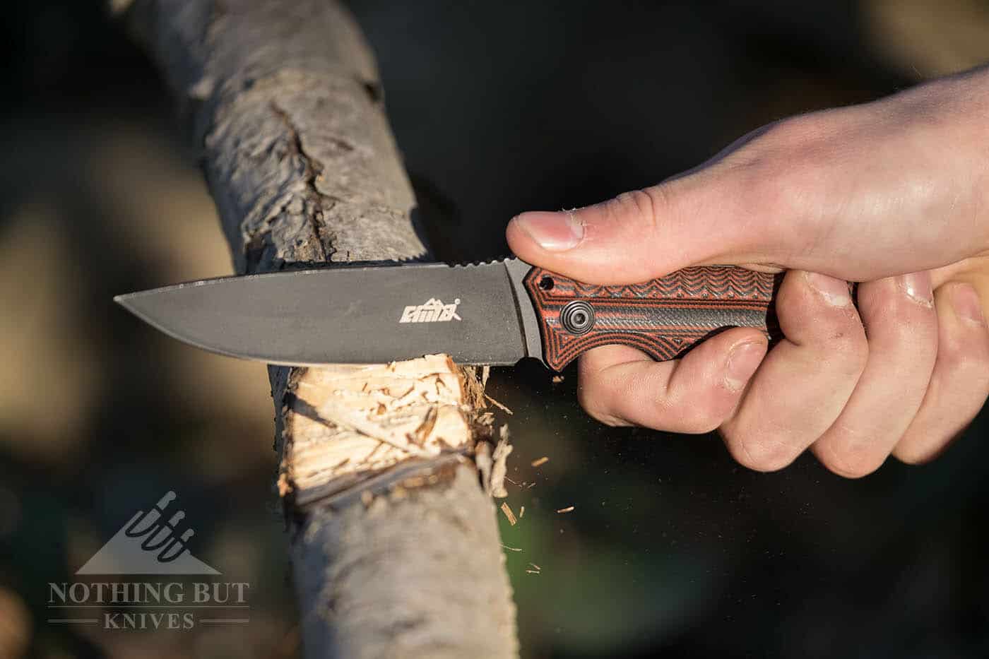 Cima G20 Review - Image 6 The Cima G20 Survival Knife chopping a tree limb in the forest.