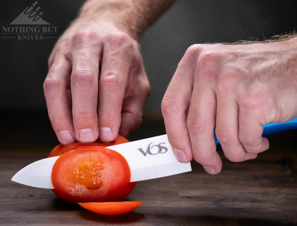 The Vos 6 inch ceramic chef knife effortlessly cuts thin slices from a tomato. 