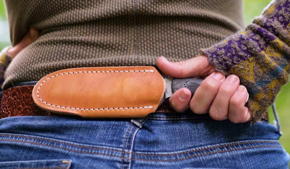 The Bradford Guardian 3 fixed blade knife shown worn in the horizontal scout carry position on a belt around a women's waist. 