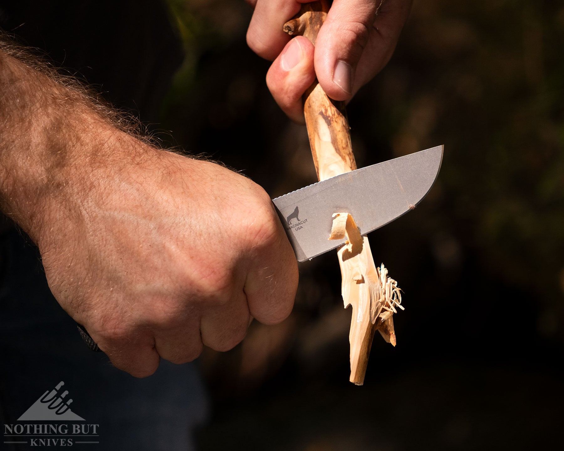 Best Horizontal Carry Knives - Continuous Update - Image 21 A slightly elevated view of the Reiff Circadian clip point knife being used to carve a stick outdoors.