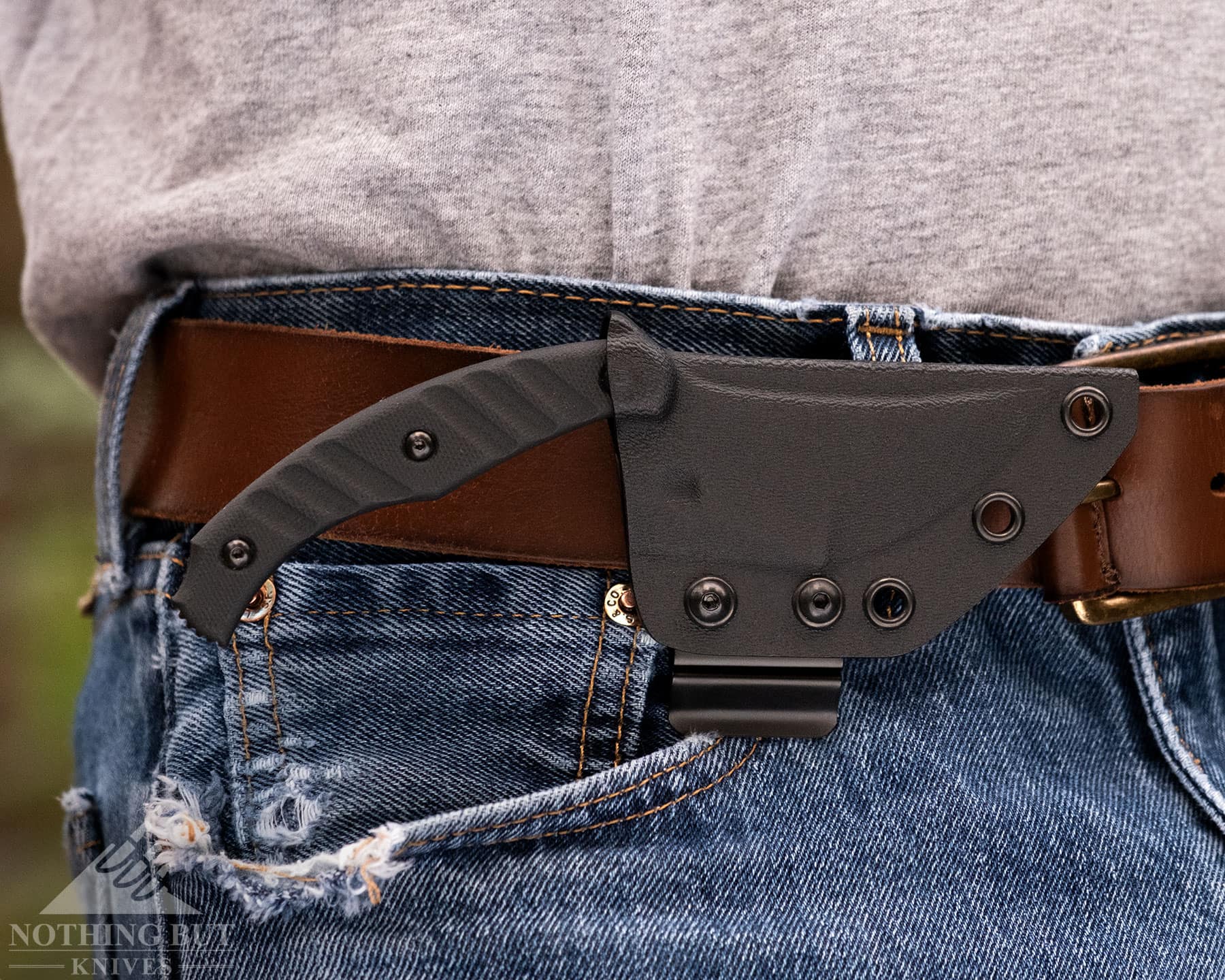 Best Horizontal Carry Knives - Continuous Update - Image 56 The TOPS Ephyra show here in its black, kydex sheath set up for front, right side horizontal carry attached to a leather belt.