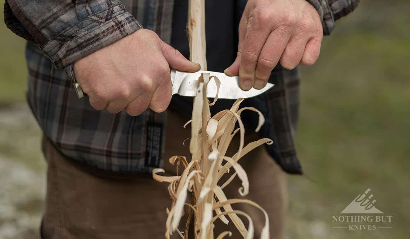 Buck Selkirk Knife Review - Image 9 A person using two hands to create a feather stick with the Buck Selkirk.