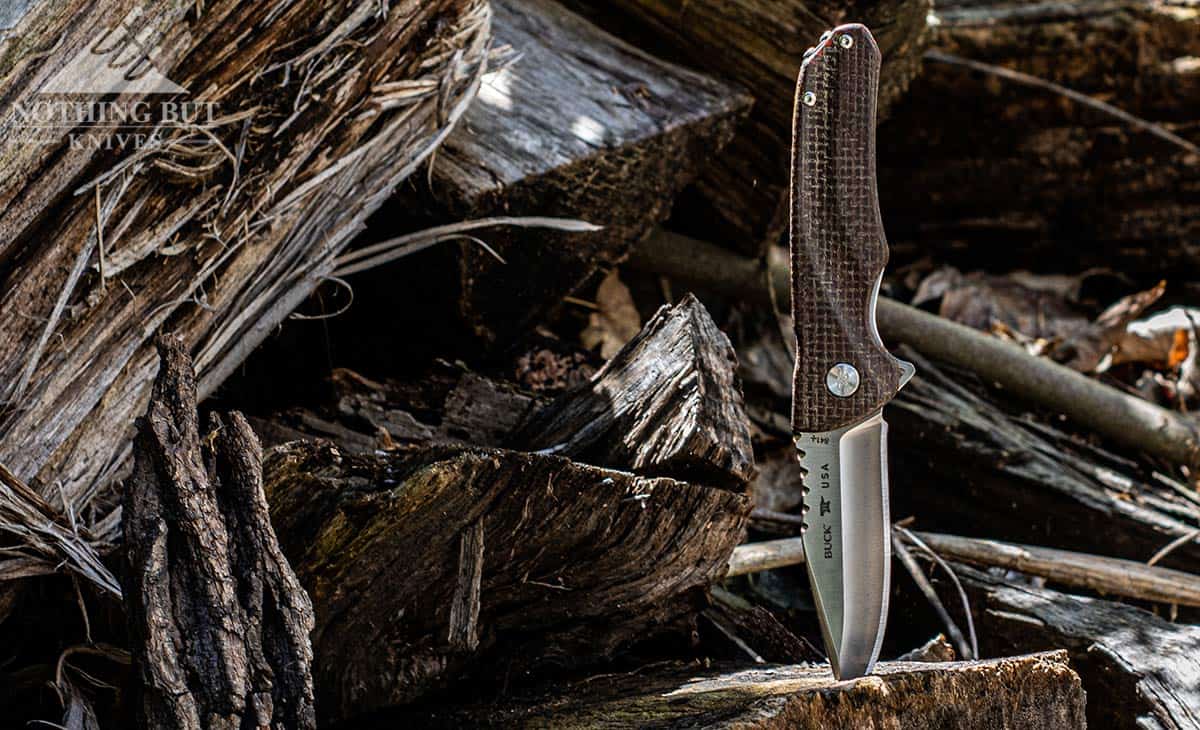 The Best Hard Use Pocket Knives Under $50 And $100 32 The burlap Micarta handled Buck Sprint Pro sticking out of a log on a woodpile.