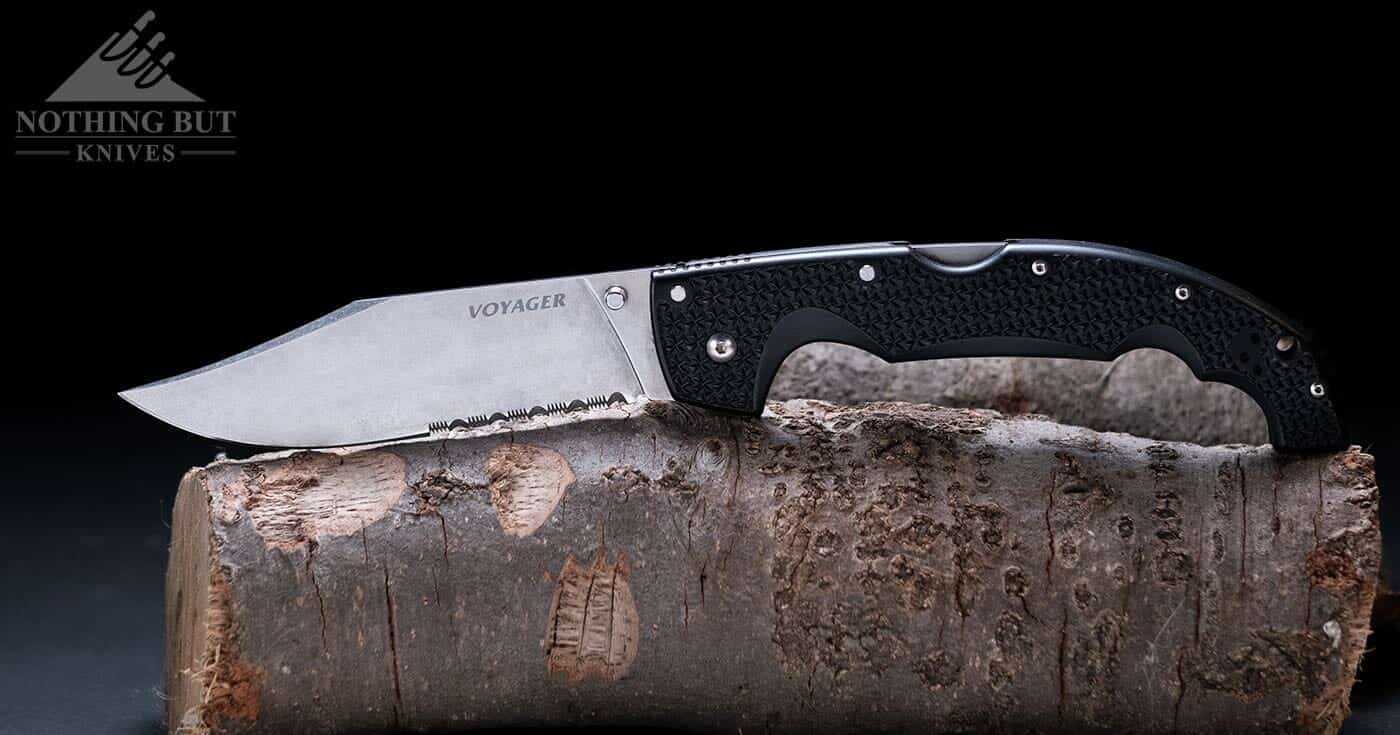 The Cold Steel Voyager folding knife sitting on a branch in the open position. 