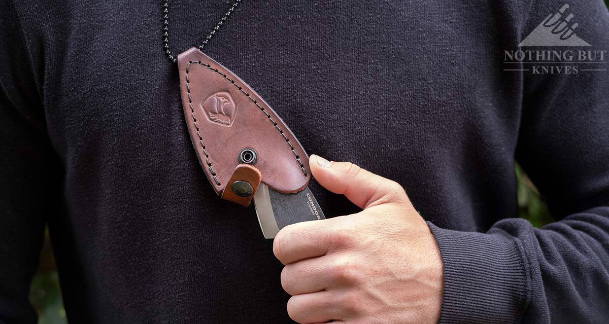 The Condor Pangui neck knife being drawn from it's leather sheath.