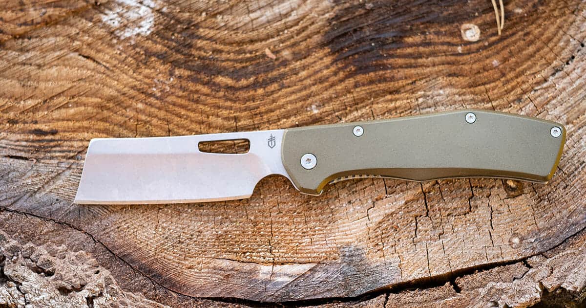 Gerber Flatiron folding cleaver pocketknife with the blade on on a tree stump. 