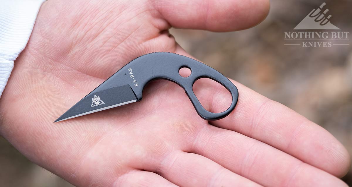 Close-up of the Ka-bar TDI LDK neck knife in a man's hand to show scale.
