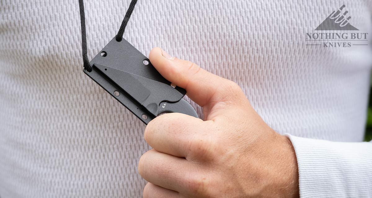 Close-up of a man's hand drawing the Ka Bar TDI LDK neck knife from it's sheath.