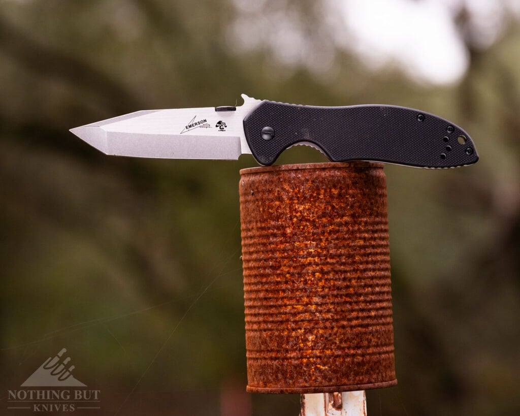 The Keshaw Emerson CQC-7K folding knife shown here in the open position balanced on a rusty tin can.
