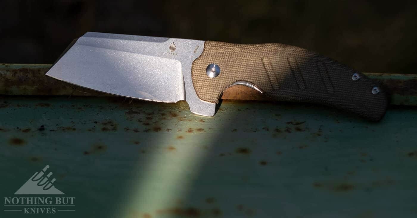 The Kizer Sheepdog sitting on a rusty of piece of metal. 