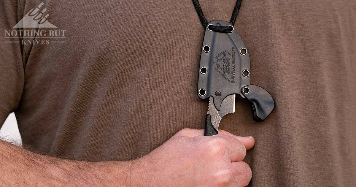 The Outdoor Edge Le Duck knife worn around a man's neck. 