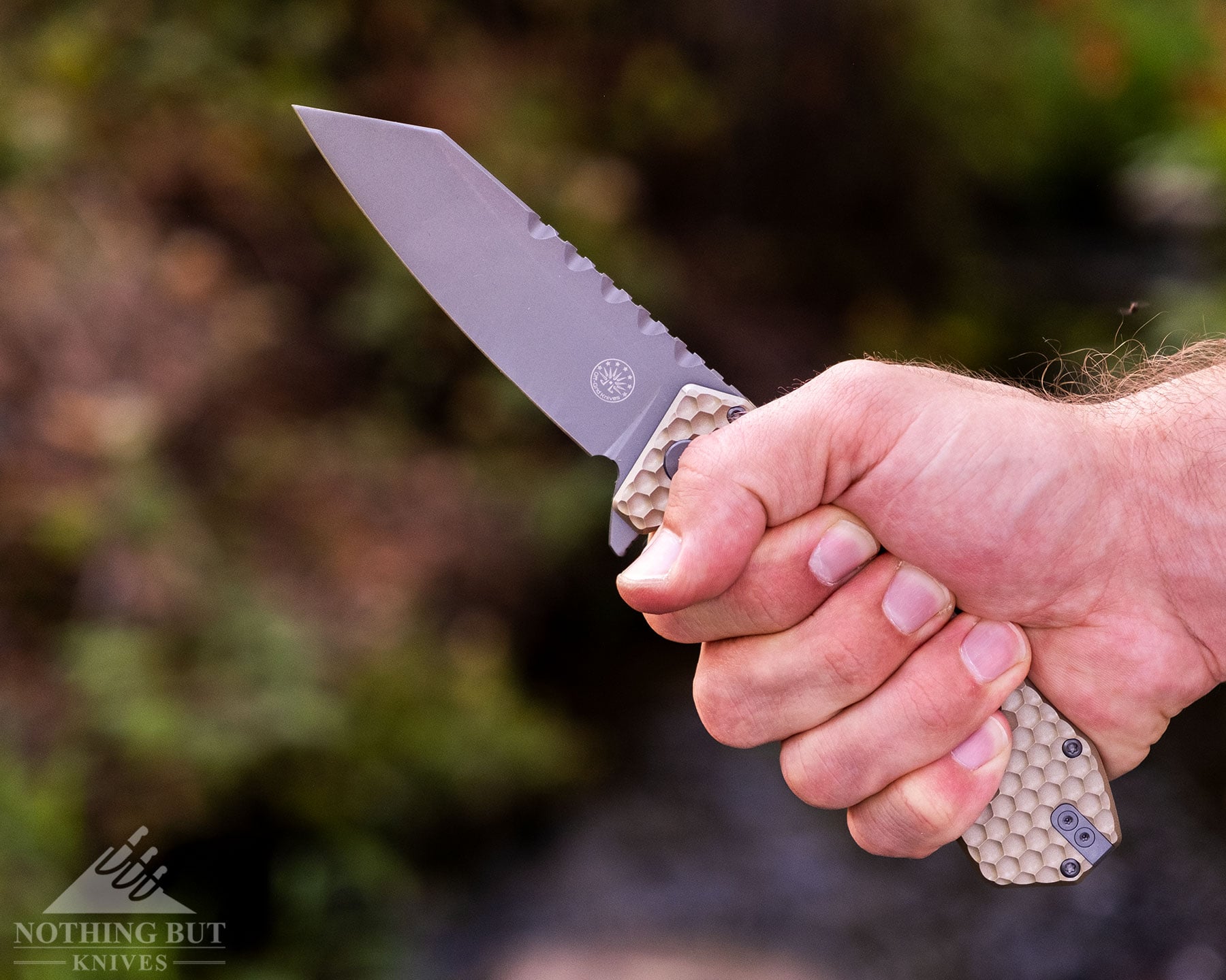 The Best Tactical Knives From Our Favorite Brands - Image 49 A profile view of the Off-Grid Black Mamba V3 folding knife being gripped in a person's right hand via a gorilla style hand grip.