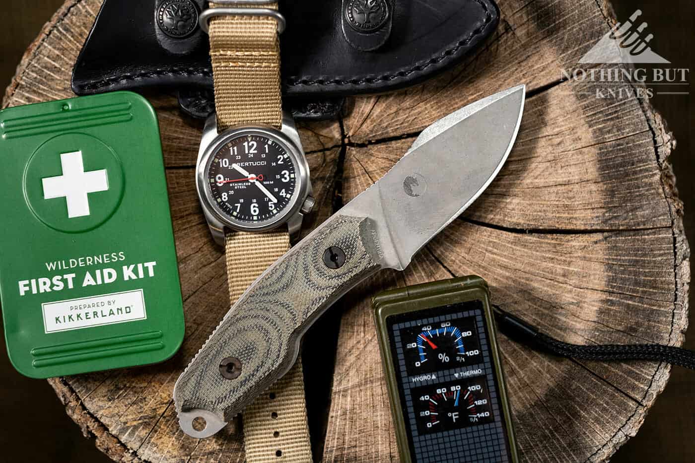 A pocket dump photo featuring the Boker El Heroe knife, a Bertucci watch, a first aid kit and a compass. 