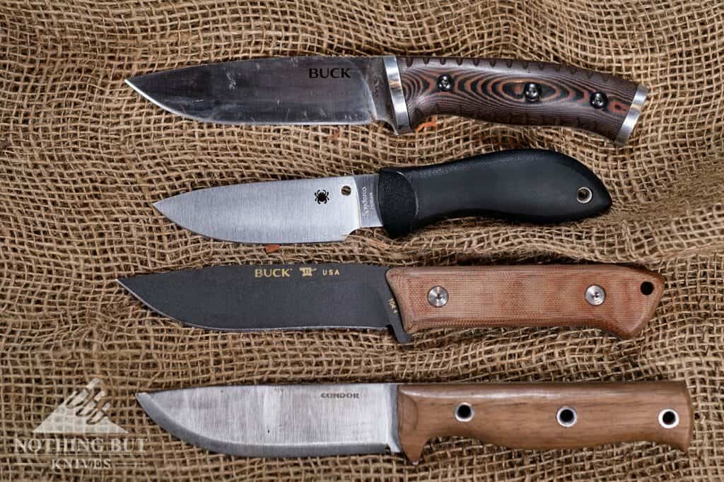 The Bill Moran Upswept Bowie on a table with the Buck Selkirk, Buck Compadre, and Condor Swamp Romper knives. 