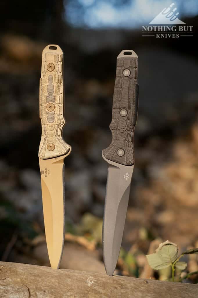 Two different Buck Ground Combat Knives sticking out of a stump.