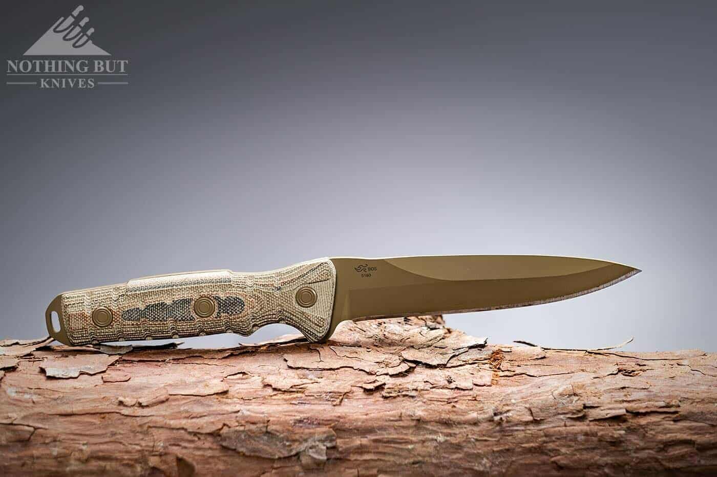 The Coyote Tan Spearpoint Buck Ground Combat Knife on a log.