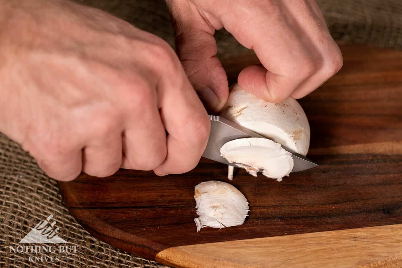 Off-Grid Knives Badger Review - Image 15 A folding knife slicing through mushrooms.