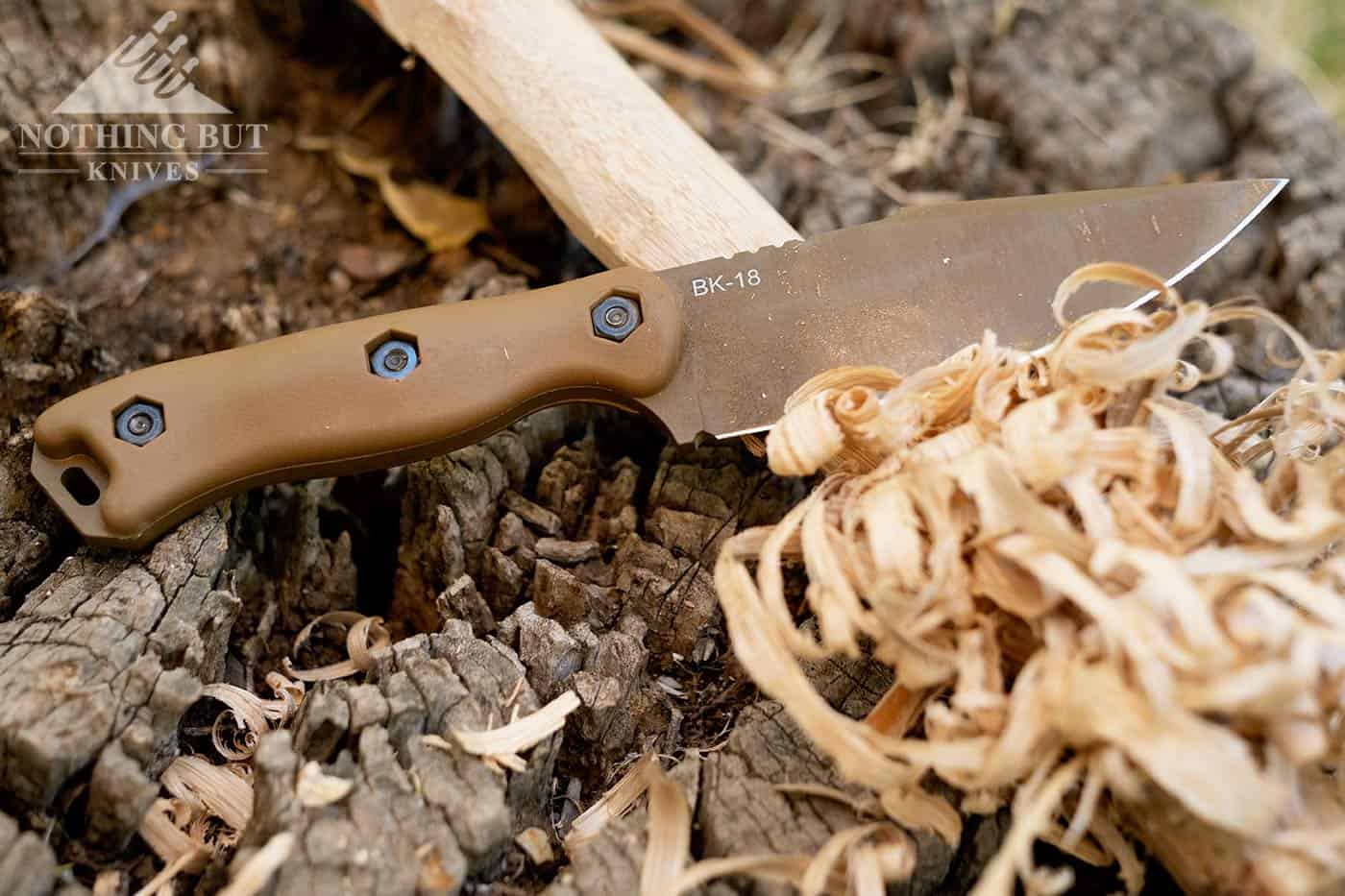 Still life of the Ka-Bar Becker BK-18 on a tree stump next to a feather stick that it just made