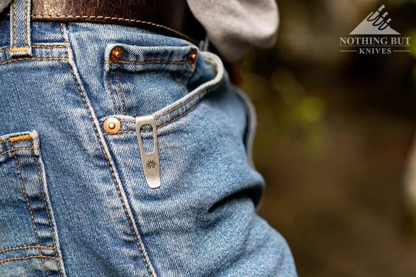 A pocketknife in sitting deep in the pocket of a pair of jeans. 