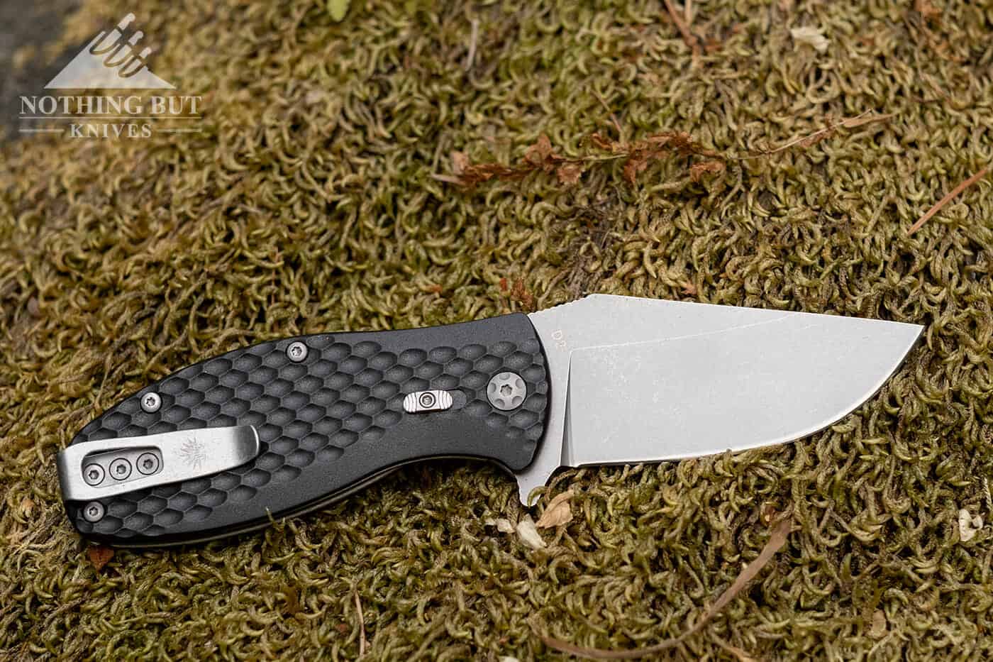 Off-Grid Knives Badger Review - Image 2 Off-Grid Badger on a mossy rock.