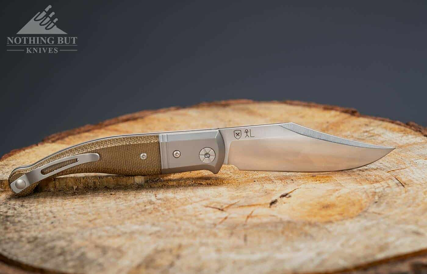The LionSteel Gitano knife on a stump with it's blade open. 