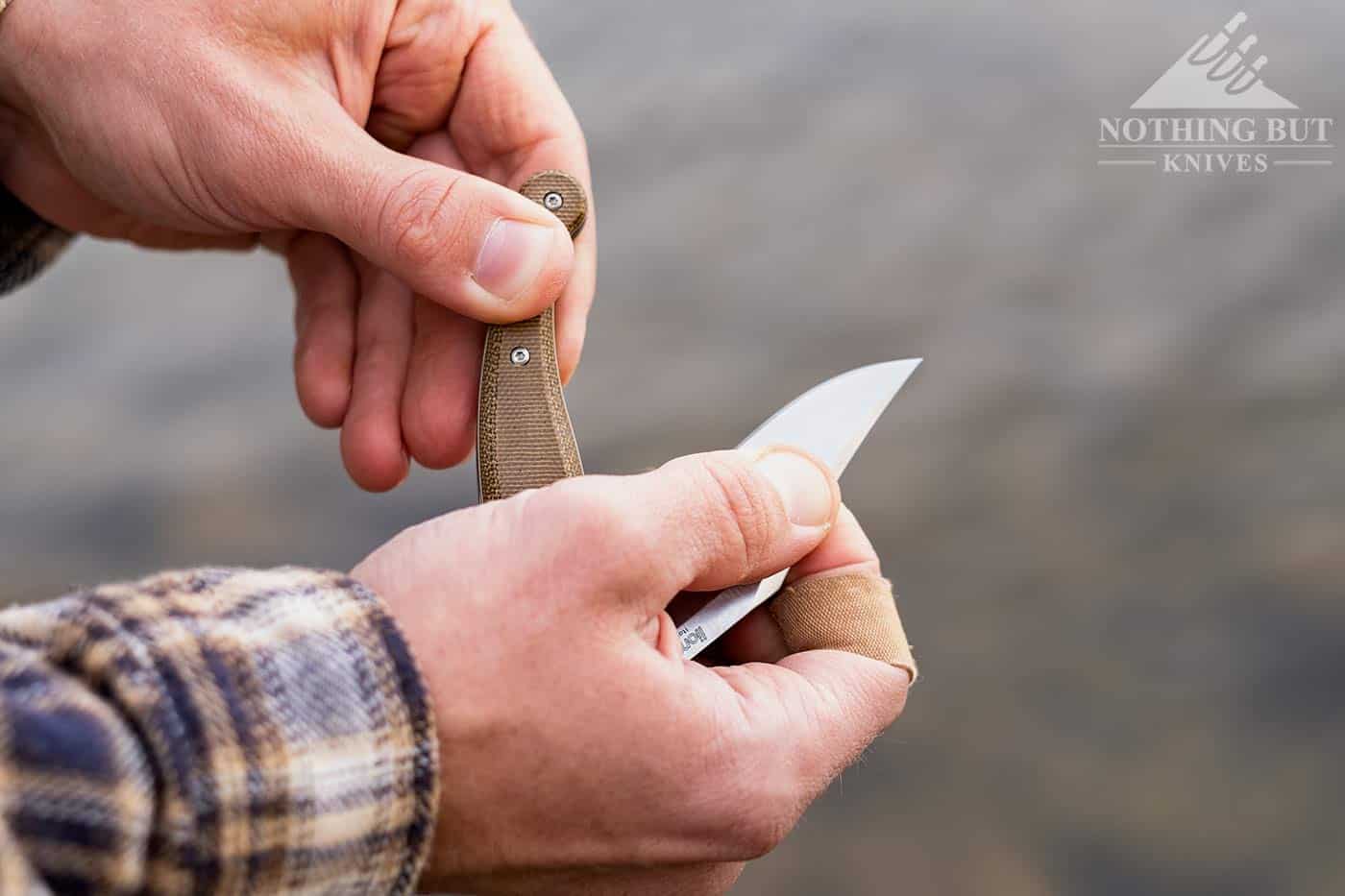 Lionsteel Gitano Slip Joint Review - Image 9 A man's hands closing the LionSteel Gitano knife above a river.