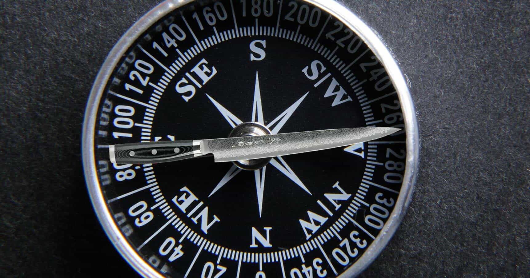 Custom graphic Yaxell Gou slicing knife being used as the needle on a compass in the East West position. 