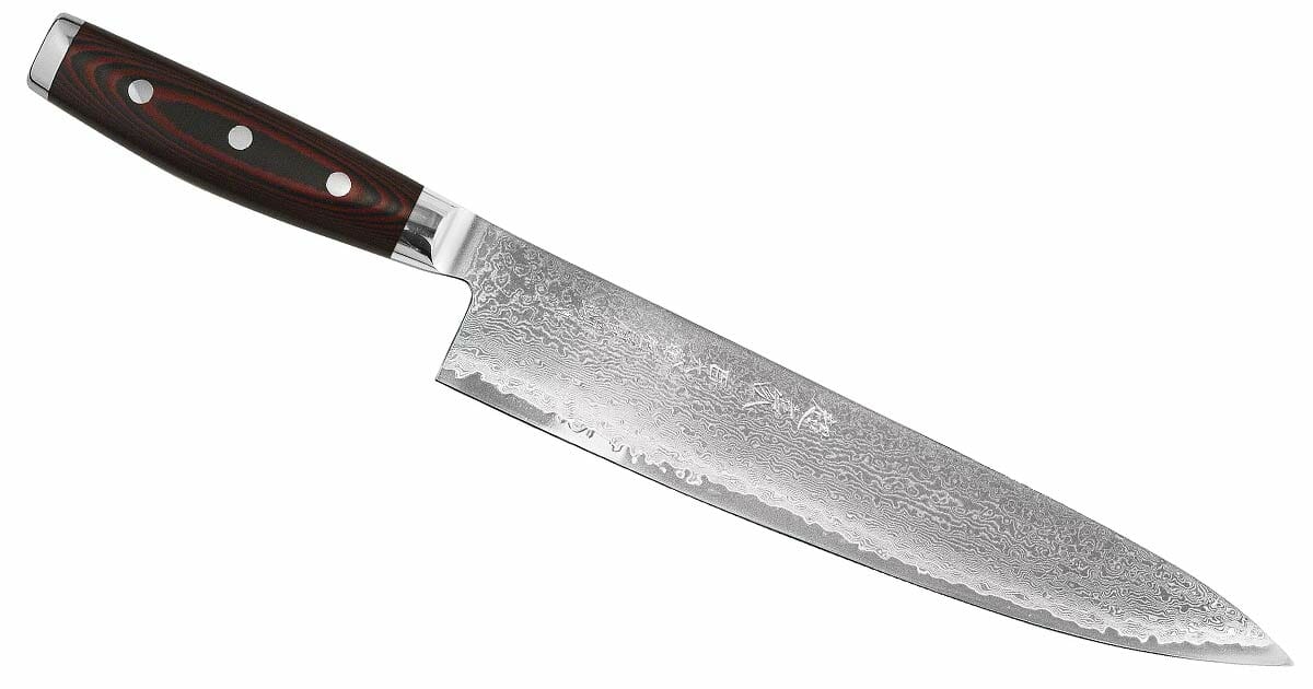 The Yaxell Super Gou 8 inch chef knife with a red micarta handle on a white background. 