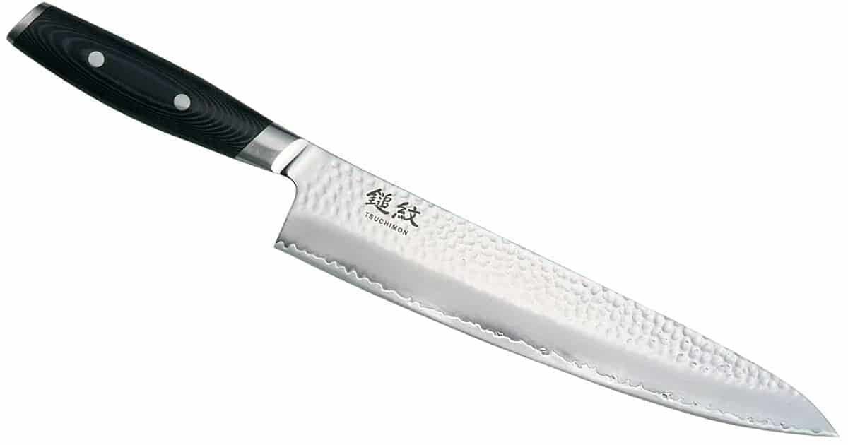 The Yaxell Tsuchimon 8 inch chef knife with the blade angled to the right on a white background.