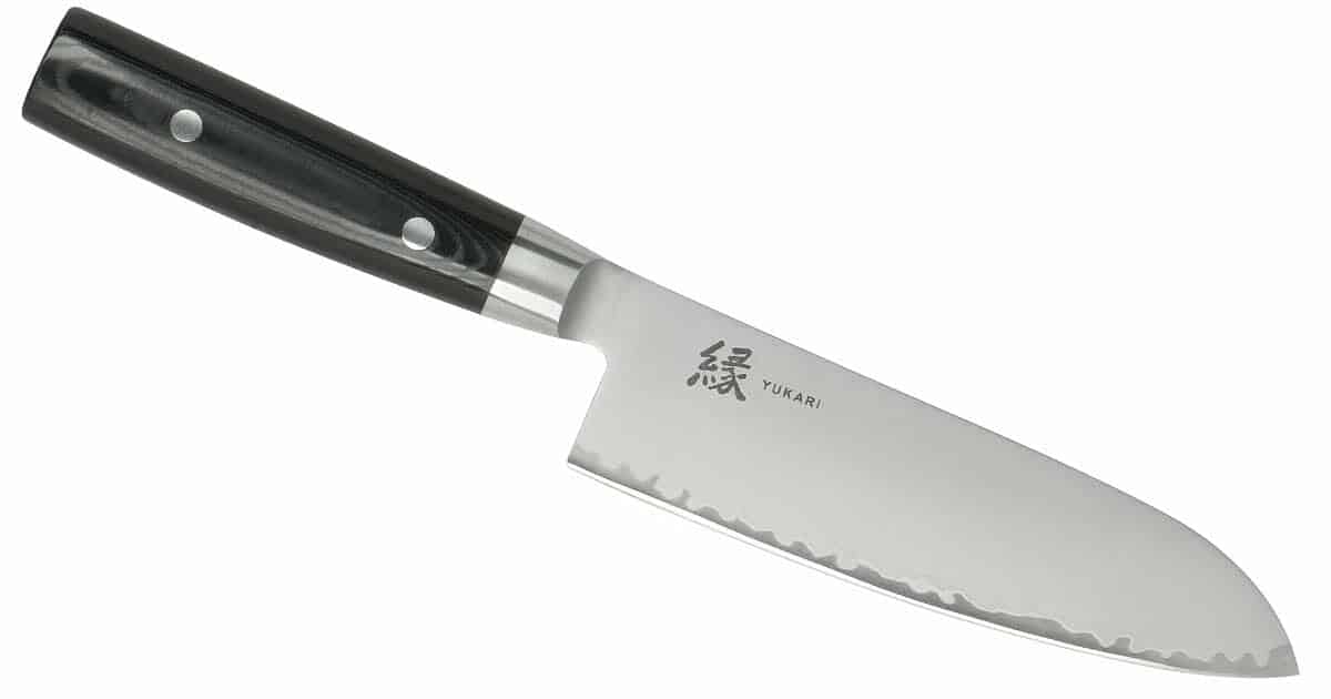 The Yaxell Yukari 6.5 inch santoku knife with MOVAX steel angled with the blade down and to the right on a white background. 
