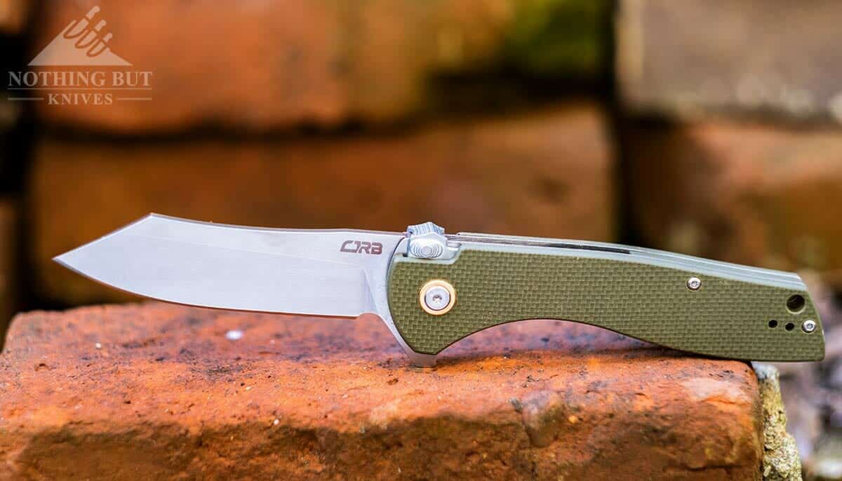 The CJRB Kicker folding knife with a D2 blade on top of a pile of bricks. 