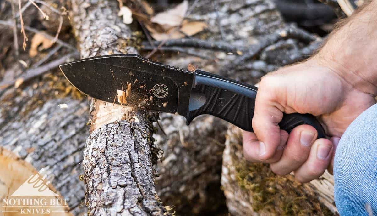 A close up of the Off-Grid Alpha Dog D2 steel knife chopping through an Oak branch.