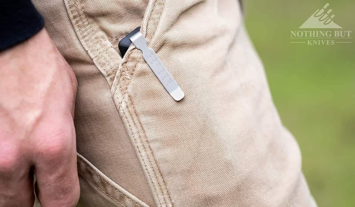 The deep carry pocket clip of the Sedulo clipped over the pocket of a man's pants. 