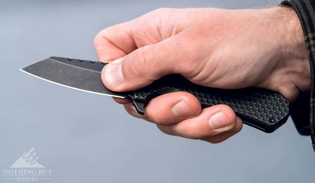 A man's hand holdingthe Off-Grid Black Mamba knife in a pinch grip. 
