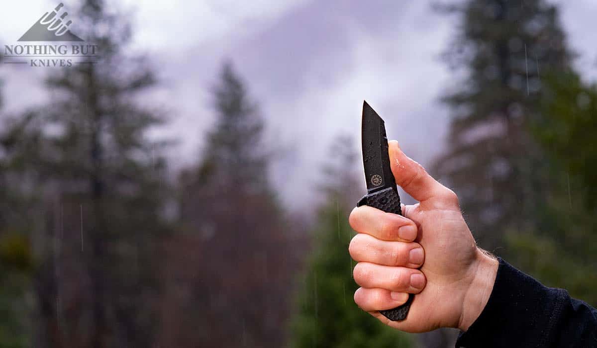 Off Grid Black Mamba Review - V3 Update - Image 10 The Black Mamba knife in the mountains in a man's hand.