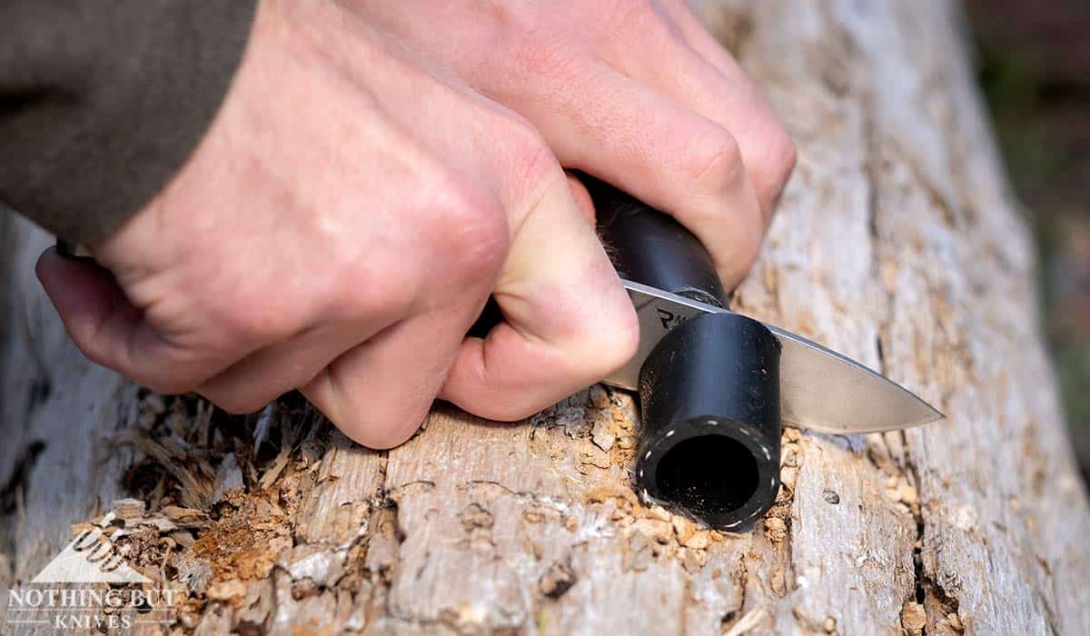 A close-up of the Sedulo pocketknife slicing through a rubber hose. 