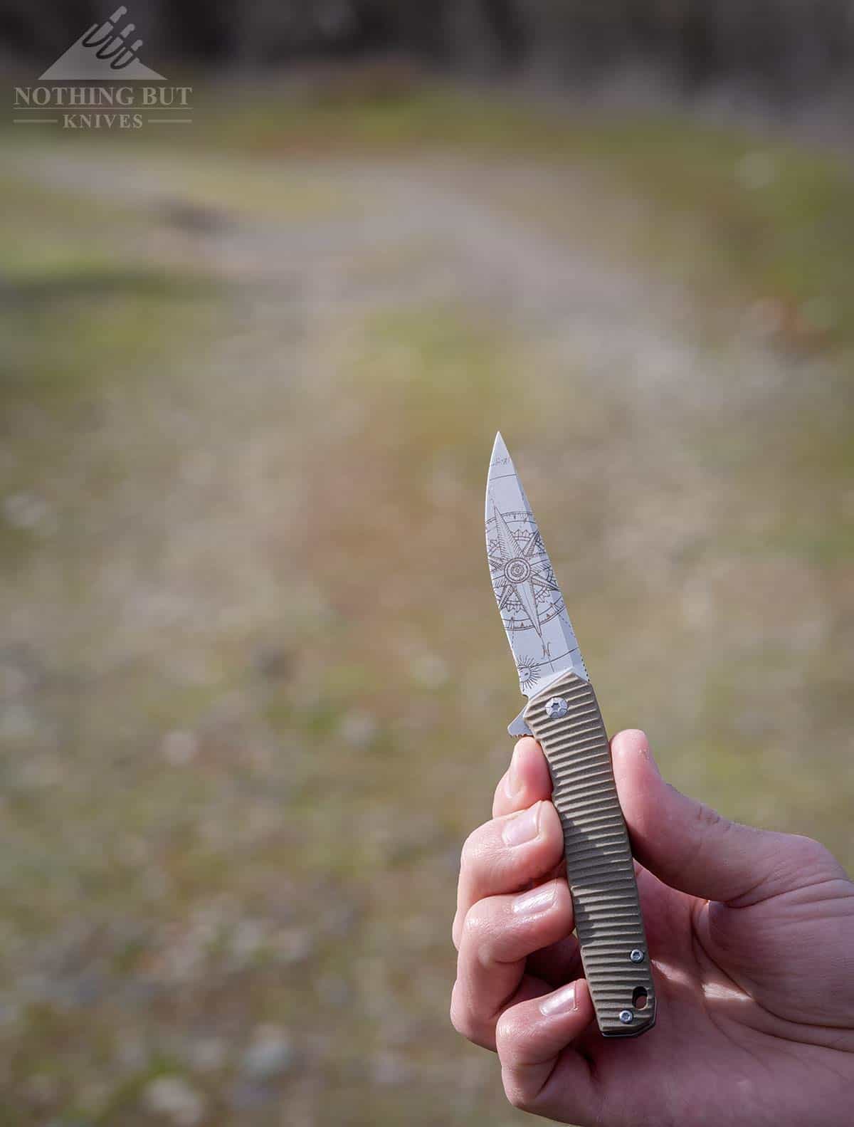 3V Gear React Knife Review - Image 12 The Compass version of the 3V Gear React pointing down a dirt road.