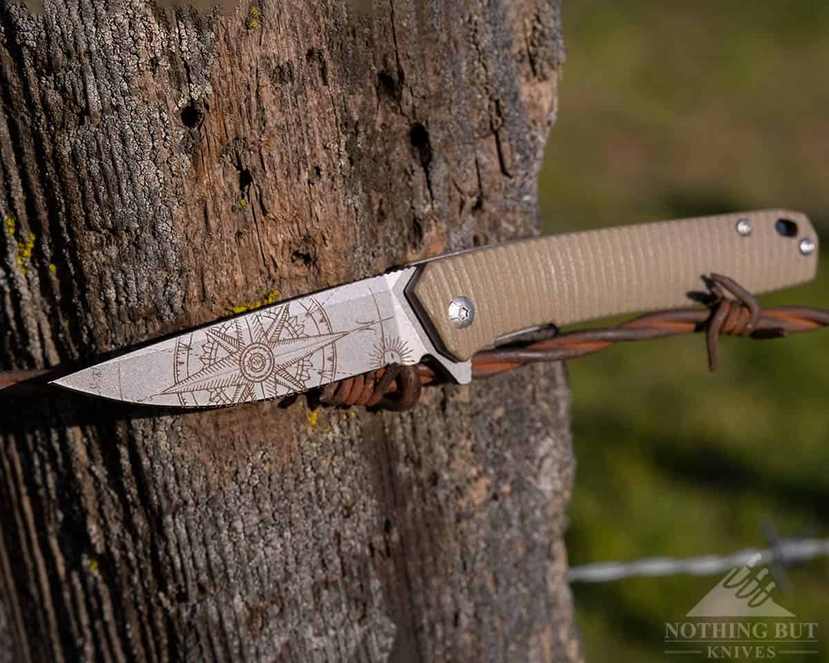 3V Gear React Knife Review - Image 11 The 3V Gear React on a barbed wire fence.