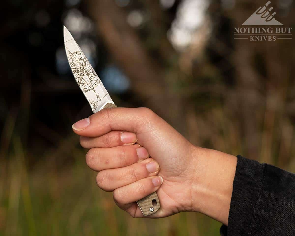 A woman's hand gripping the 3V Gear pocket knife.