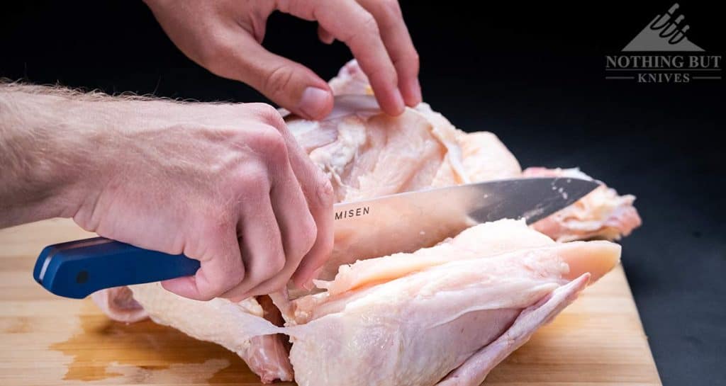 Removing a chicken breast from a whole chicken with the Misen chef knife. 