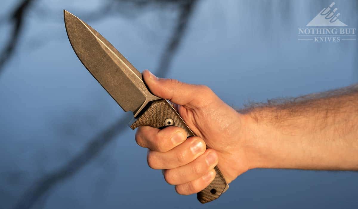A man's hand holding the LionSteel T5 in the Filipino grip. 