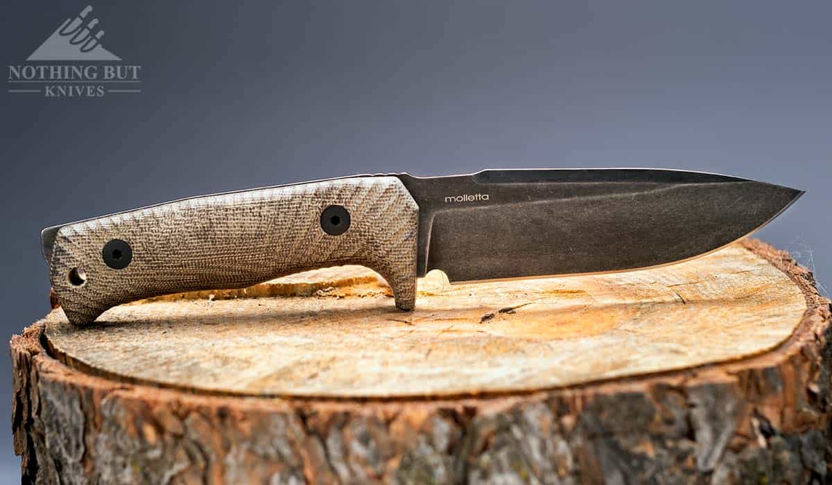 The Lion Steel T5 knife on a stump with the blade pointed to the right.