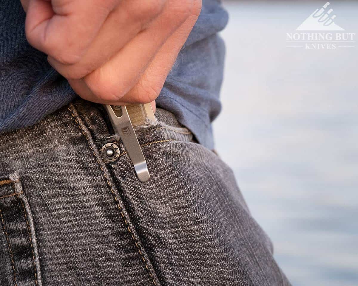 A man's hand removing the React pocket knife from his pocket. 