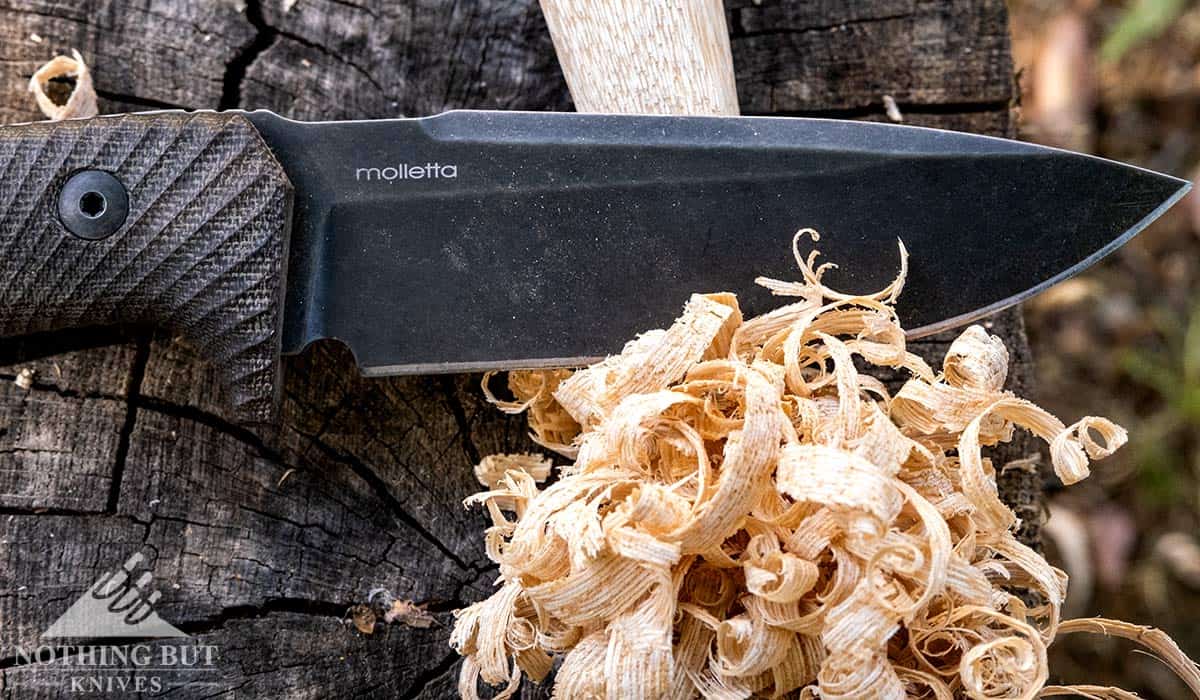 A feather stick made with the lionSteel T5 on a tree stump outdoors. 